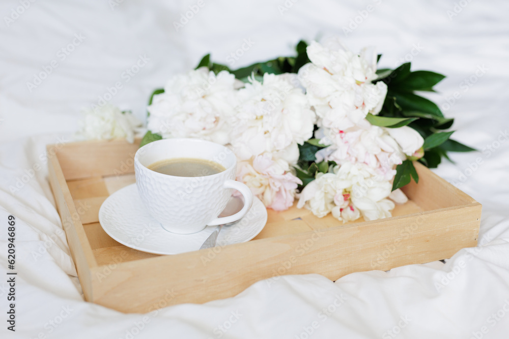 The atmosphere of a romantic morning, coffee in bed with peony flowers