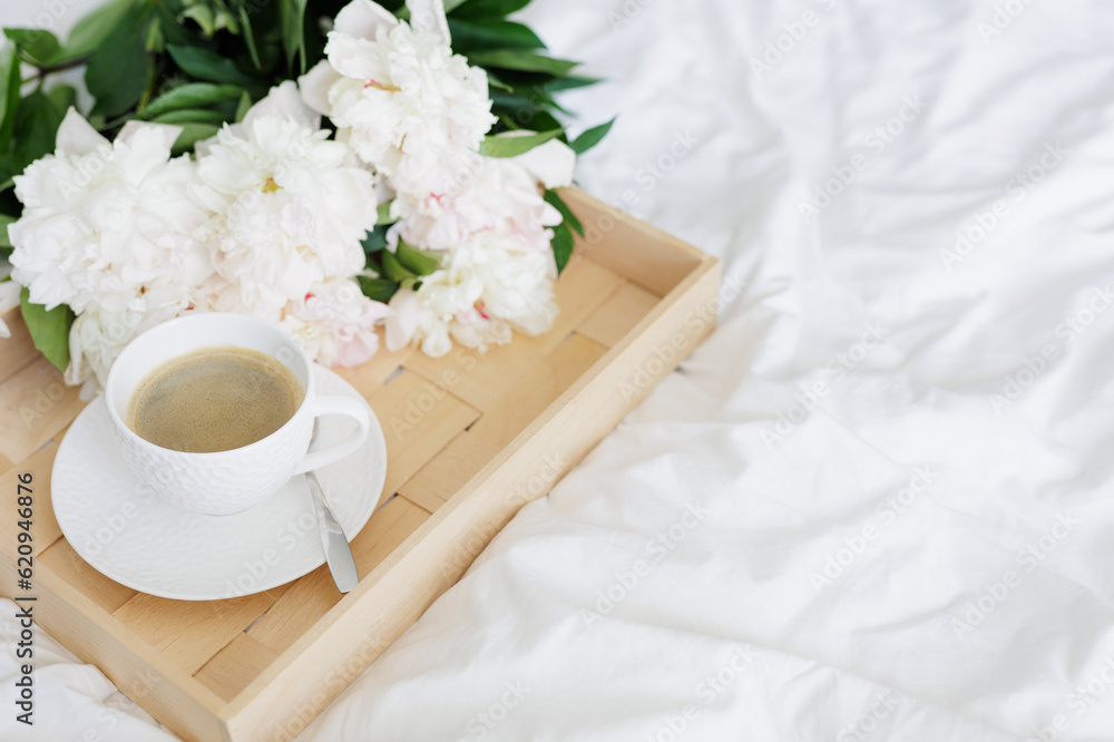 The atmosphere of a romantic morning, coffee in bed with peony flowers on tray The atmosphere of a romantic morning, coffee in bed with peony flowers on tray