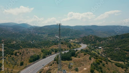 Telecommunication cellular tower 5G near highway with car traffic. Telecom tower antenna in countryside in hyghway photo