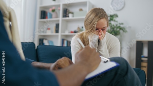 Crying woman talking to psychologist, psychotherapy session, victim of violence
