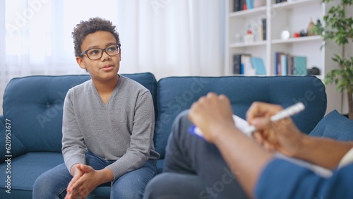 African American pre-teen boy having conversation with school psychologist, child therapy