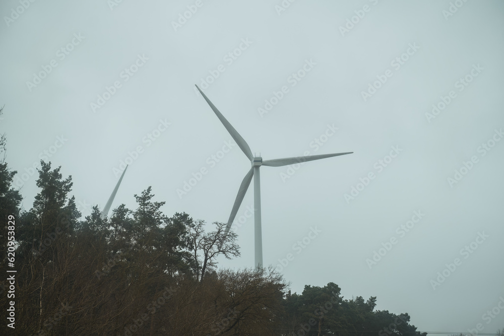 Wind turbines landscape. Green energy concept. Panoramic view of a wind park with high wind turbines for generation of electricity with copy space. Wind turbines landscape. Green energy concept. Panoramic view of a wind park with high wind turbines for generation of electricity with copy space.