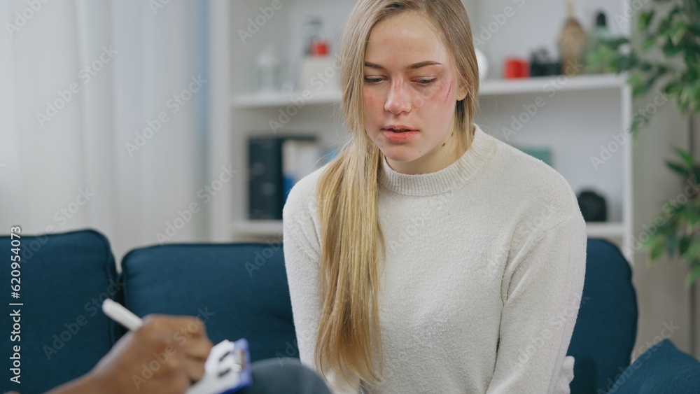 Injured young woman talking to psychologist, professional counseling for abuse survivors Injured young woman talking to psychologist, professional counseling for abuse survivors