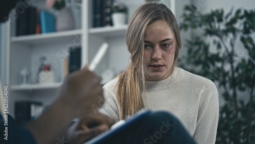 Fotografie Woman domestic violence victim with injured face talking to psychologist, emotio