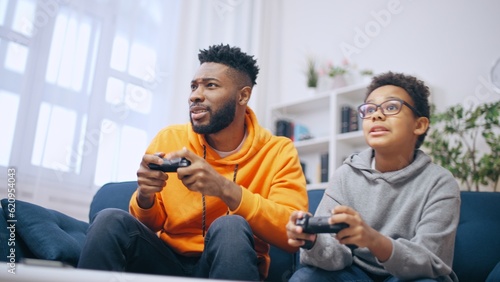 Happy African American brothers playing video game together, leisure time at home
