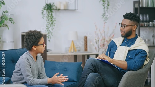 Wallpaper Mural Friendly school psychologist talking to little boy, mental health assessment, support Torontodigital.ca