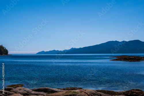sea sky and mountains with rocky beach foreground shot in fitz hugh sound, british columbia
