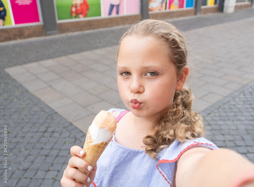 Girl, teenage girl eats ice cream and takes a selfie on a smartphone, mobile phone. Teen addiction to social networks, virtual friends Girl, teenage girl eats ice cream and takes a selfie on a smartphone, mobile phone. Teen addiction to social networks, virtual friends