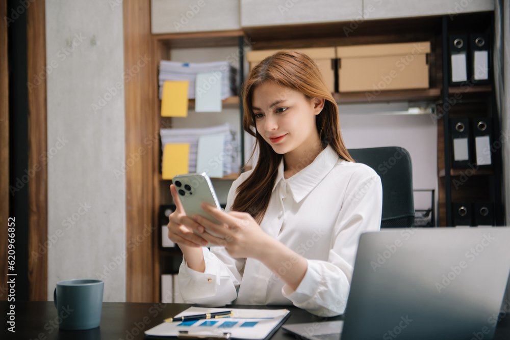 Young beautiful woman typing on tablet and laptop while sitting at the working wooden table office. Young beautiful woman typing on tablet and laptop while sitting at the working wooden table office.