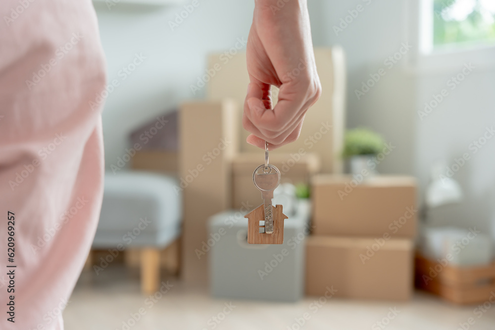 Moving house, relocation. Woman hold key house keychain in new apartment. move in new home. Buy or rent real estate. flat tenancy, leasehold property, new landlord, dwelling, loan, mortgage..