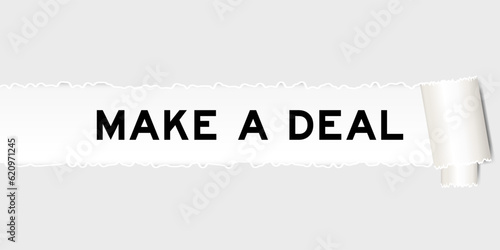 Ripped gray paper background that have word make a deal under torn part