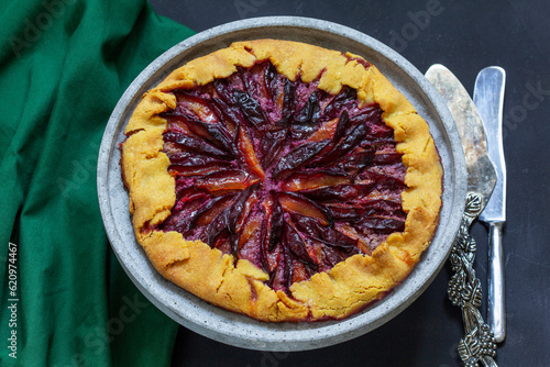 Obraz na płótnie Traditional french pie galette made of corn dough with plum filling on a concrete tray. w salonie