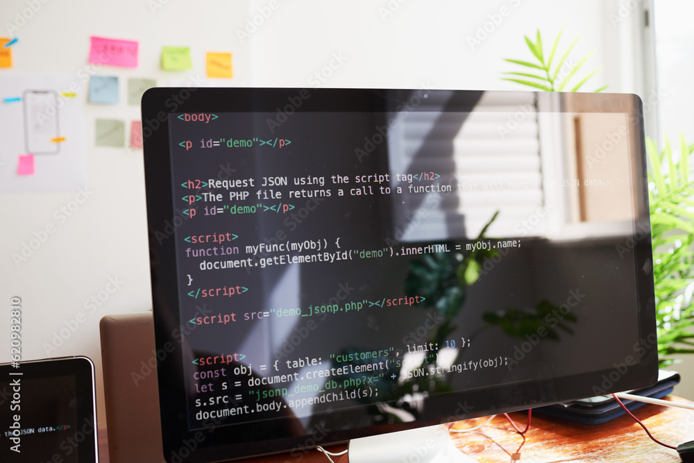 Still life of PC screen with javascript coding demo, on desk in office Still life of PC screen with javascript coding demo, on desk in office