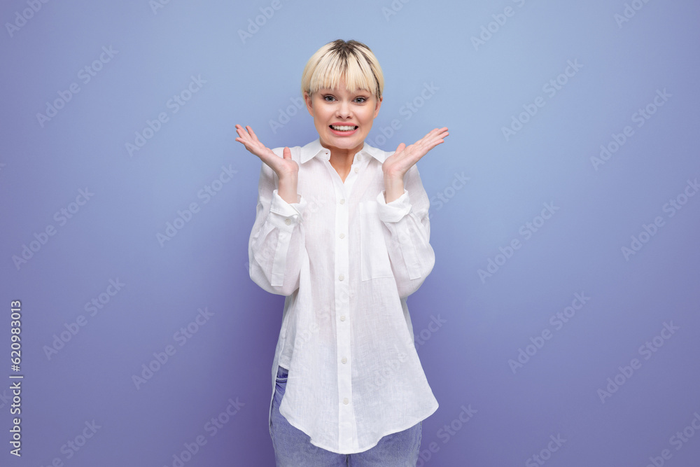 young surprised blond career woman in white shirt on blue background with copy space. people lifestyle concept young surprised blond career woman in white shirt on blue background with copy space. people lifestyle concept