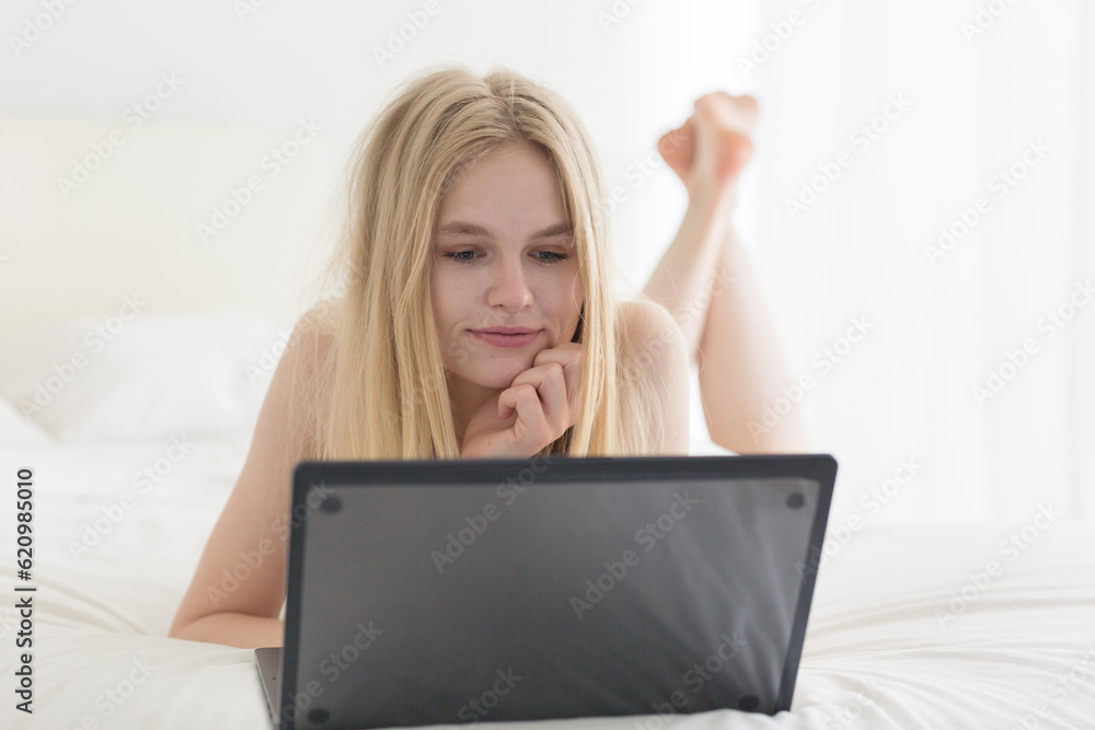 Relaxed Woman Working from Bed with Laptop in a Cozy Bedroom. Relaxed Woman Working from Bed with Laptop in a Cozy Bedroom.