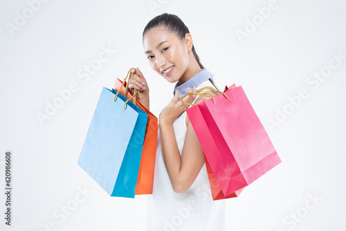 Beautiful Attractive Asian Woman smile and holding shopping bags feeling so happiness and enjoy with black Friday sale in Shopping mall,isolated on white background. Shopping Lifestyle Concept