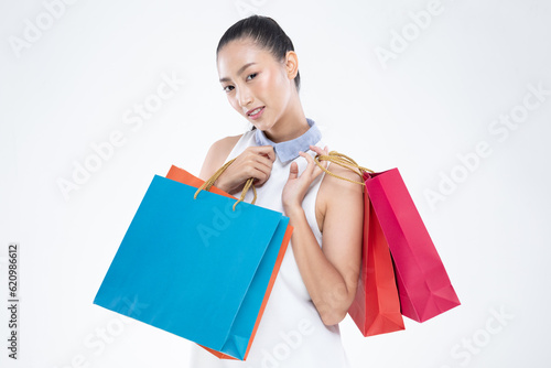 Beautiful Attractive Asian Woman smile and holding shopping bags feeling so happiness and enjoy with black Friday sale in Shopping mall,isolated on white background. Shopping Lifestyle Concept