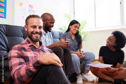 Group of diverse colleagues brainstorm together, informal meeting sit on floor