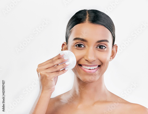 Woman, face and cotton pad, beauty and makeup remover with skincare isolated on white background. Smile, portrait and dermatology, skin health and glow with young female model and clean facial