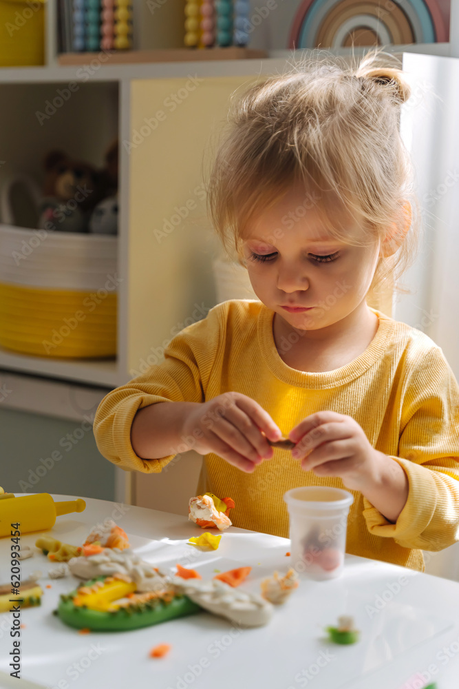 A little girl playing with rainbow from play dough for modeling with decorate from dried beans. Art Activity for Kids. Fine motor skills. Sensory play for toddlers. A little girl playing with rainbow from play dough for modeling with decorate from dried beans. Art Activity for Kids. Fine motor skills. Sensory play for toddlers.