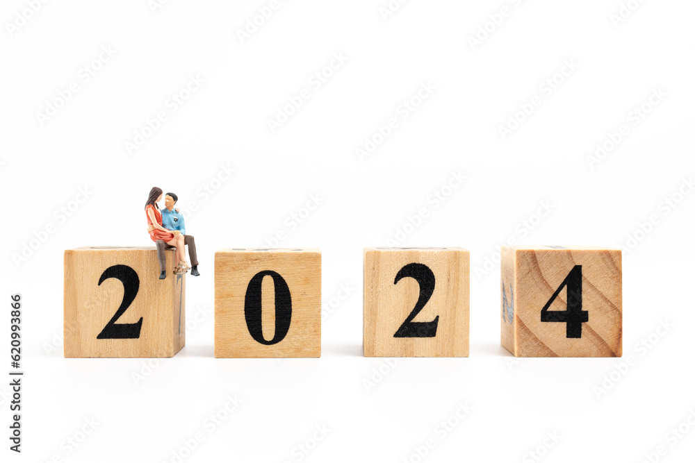 Miniature People Couple sitting On Wooden Block Number 2024