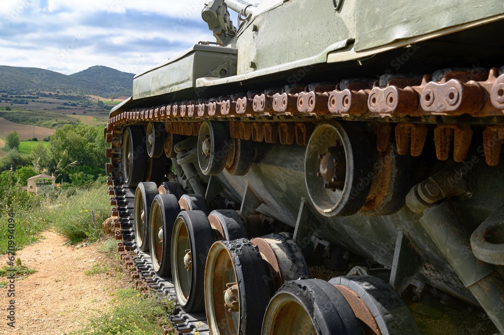 Close-up of the caterpillar, of the chains and traction wheels of an old tank, armored car, military green, M60 Patton of the American army in Europe and later of the Spanish army
