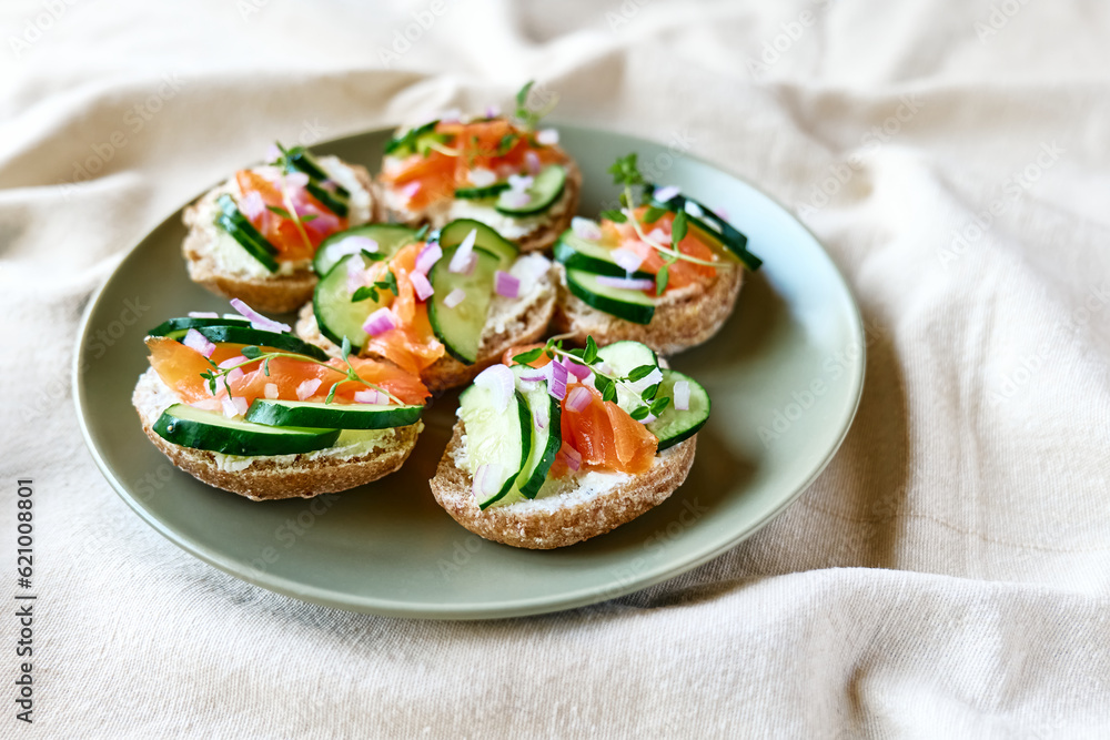 Open sandwiches with smoked salmon, cream cheese and sliced cucumber. Summer bruschetta appetizer ideas. Healthy eating.