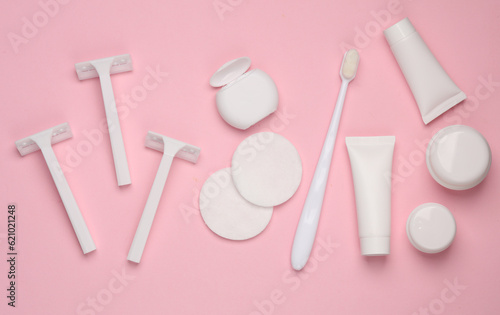 White mockups of beauty products. Just hygiene. Razors  cotton pads  dental floss  toothbrush  tubes and jars of cream on a pink background. Flat lay
