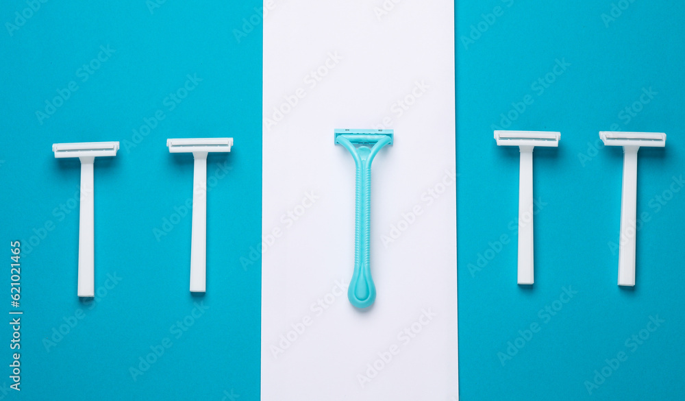 Disposable plastic razors on blue white background, minimalism beauty still lefe. Top view. Creative layout Disposable plastic razors on blue white background, minimalism beauty still lefe. Top view. Creative layout