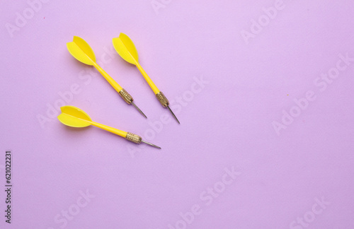 Yellow darts needles on purple pastel background