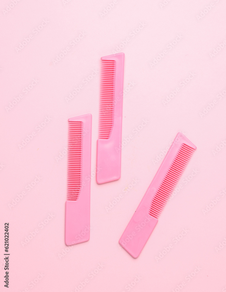 Pink plastic combs on pink background. Beauty and fashion minimalism still life