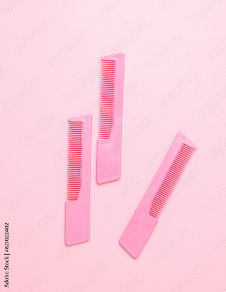 Pink plastic combs on pink background. Beauty and fashion minimalism still life Pink plastic combs on pink background. Beauty and fashion minimalism still life