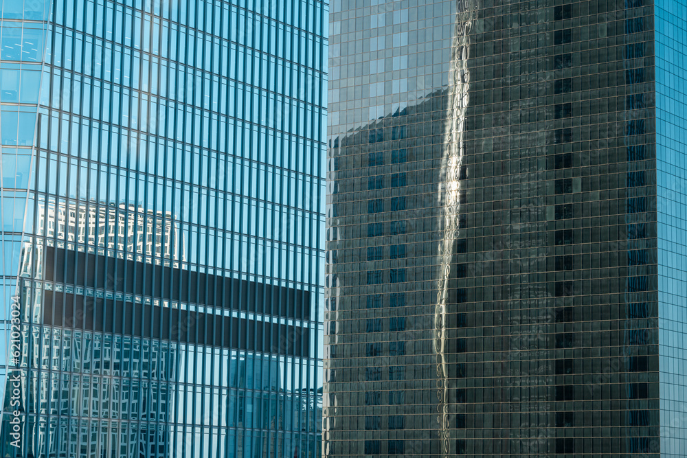 Reflection of other buildings and the sky on the glass walls of modern buildings