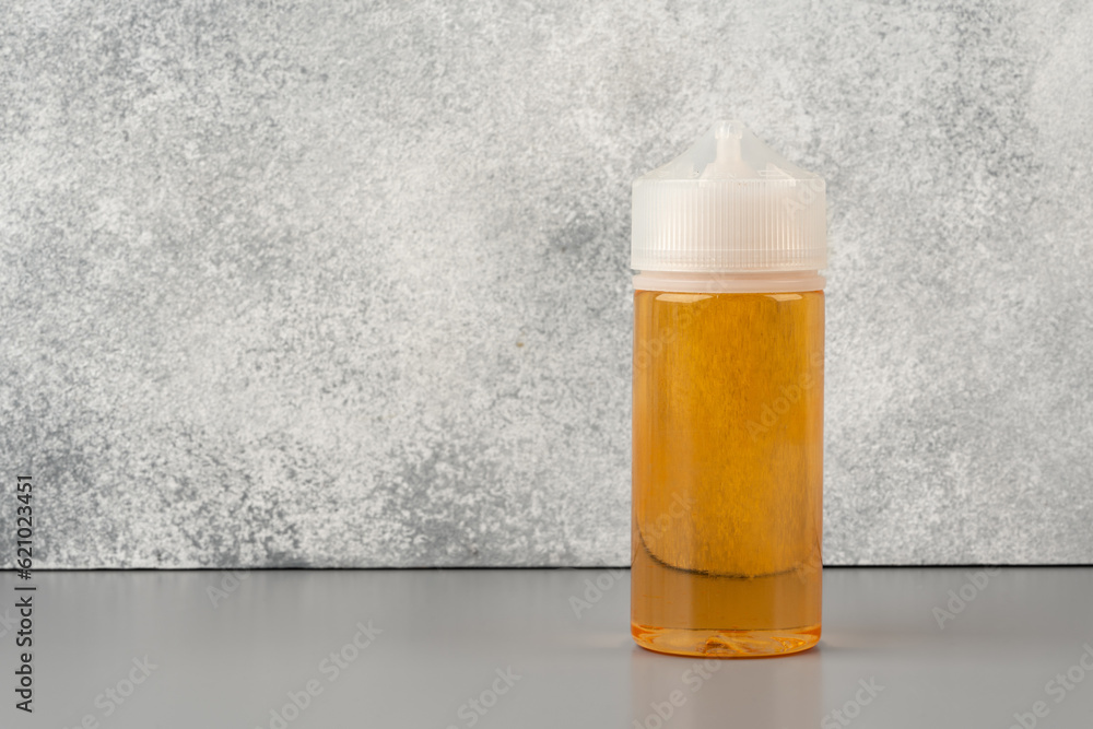 Refill liquid for electronic cigarettes on gray background Refill liquid for electronic cigarettes on gray background
