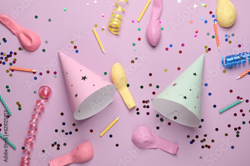 Birthday cone caps, confetti, candle and balloons on pastel background. Party concept. Top view