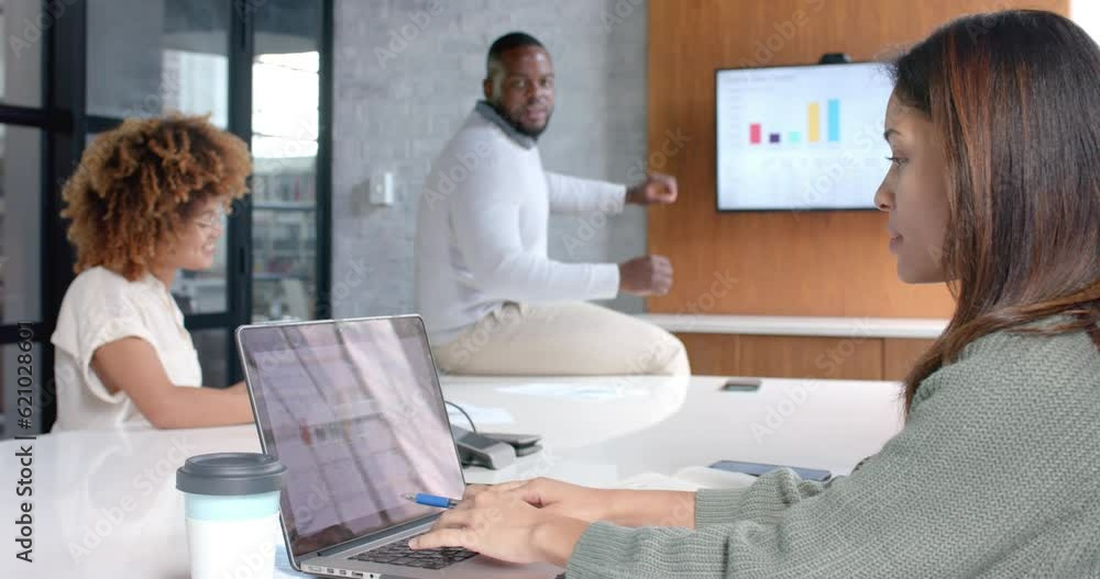 Diverse male and female colleagues using laptop and monitor at office meeting, slow motion Diverse male and female colleagues using laptop and monitor at office meeting, slow motion