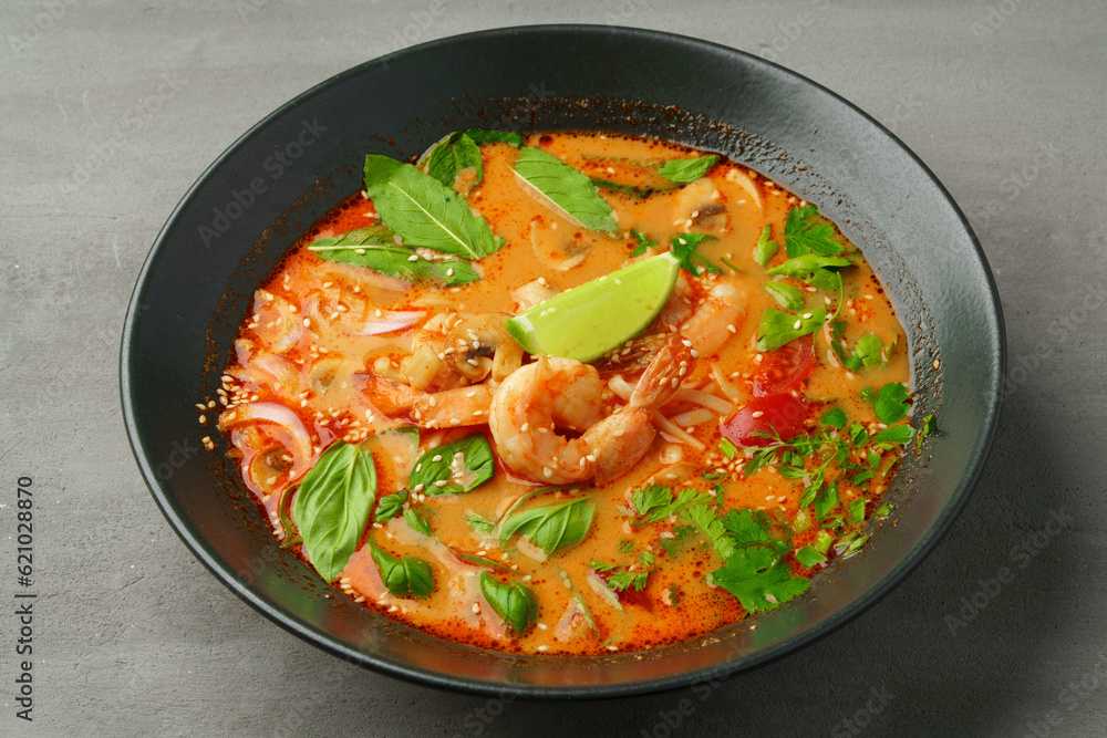 Tom Yum spicy Thai soup on gray background