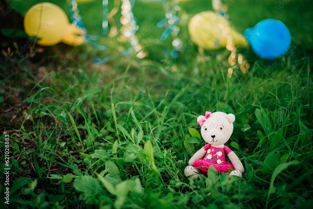 handmade knitted bear sits on the grass handmade knitted bear sits on the grass