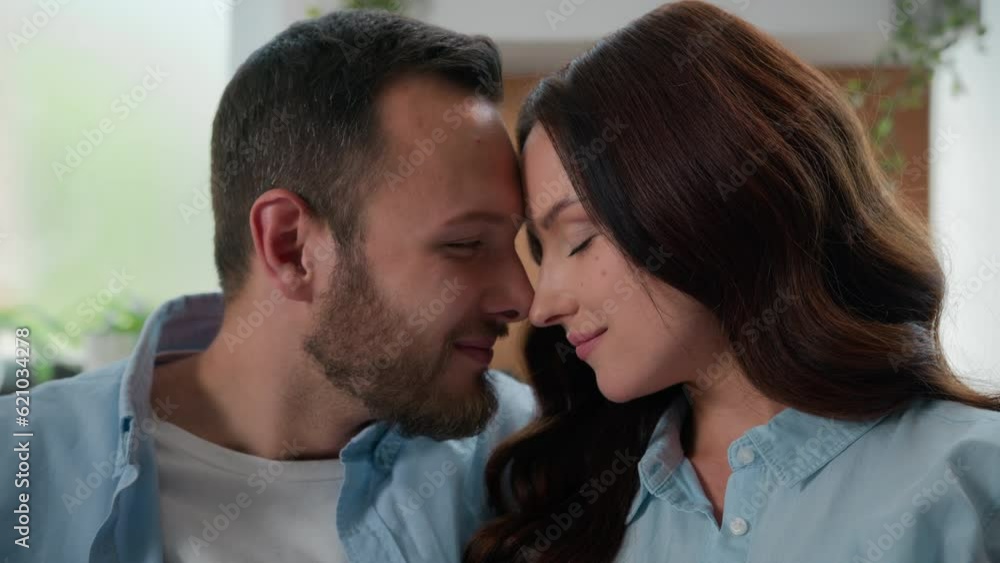 Caucasian married couple in love man and woman cuddling at home indoors noses kiss touching faces hugging tender affectionate spouses wedding boyfriend and girlfriend cuddling bond dating honeymoon