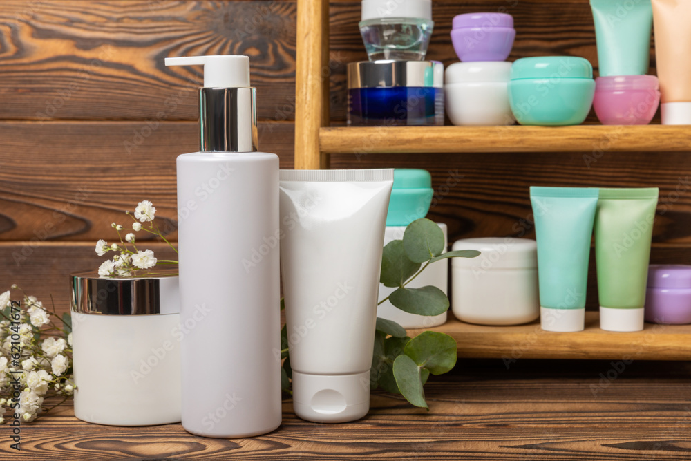 Tubes with cream on the background of a brown tabletop in the bathroom. Shelf with cosmetics. Face and body skin care. Moisturizer, toner and serum. Beauty concept. Place for text. Copy space. Tubes with cream on the background of a brown tabletop in the bathroom. Shelf with cosmetics. Face and body skin care. Moisturizer, toner and serum. Beauty concept. Place for text. Copy space.