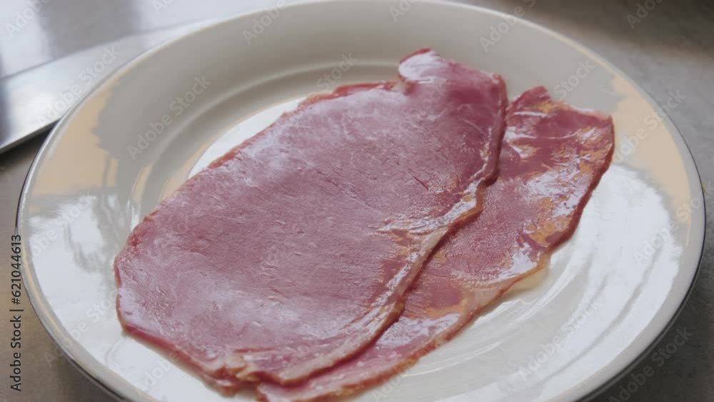 slow motion veal bacon on a white plate in macro shot slow motion veal bacon on a white plate in macro shot