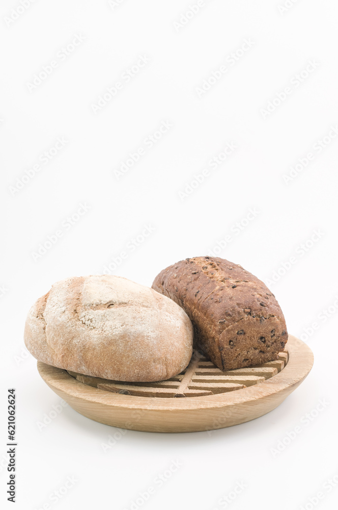 immagine primo piano di pagnotte preparate con farine integrali da agricoltura biologica, tagliere in legno su sfondo bianco