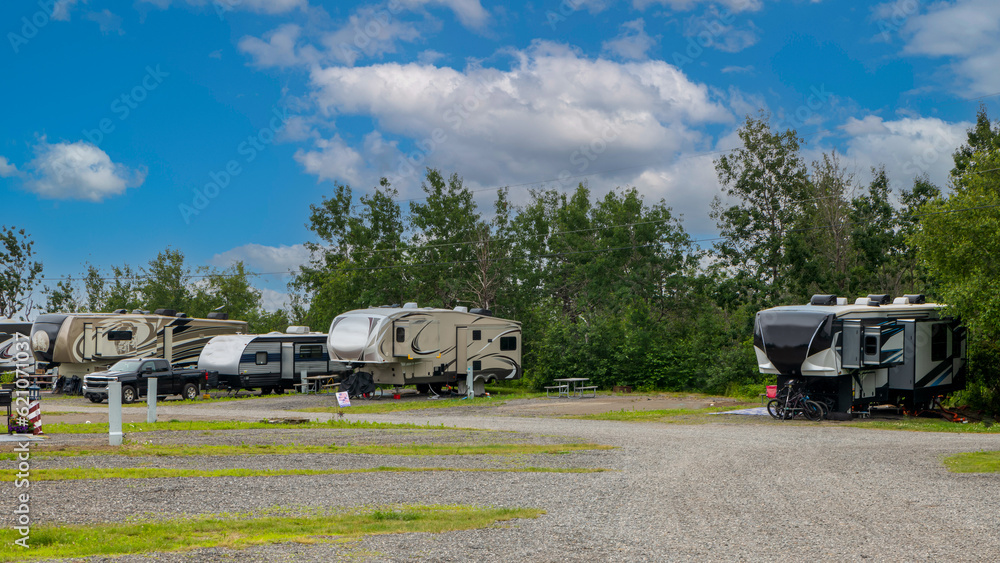 Rv motorhomes camping at campsites trees clouds and grass