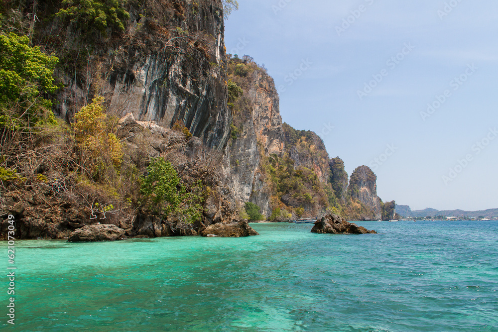 Fototapeta premium Cliff shoreline with tourquise water near Ko Phi Phi island in Thailand