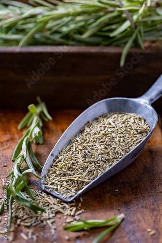Dried rosemary placed in a metal box on a wooden background