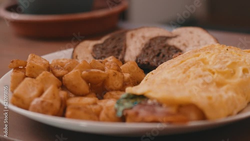 Egg Omelet, Homefries and Rye Toast on a White Plate on a wooden table in 4k photo