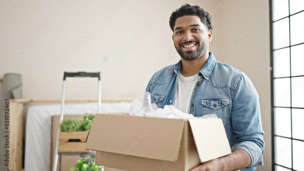 African american man smiling confident holding package at new home African american man smiling confident holding package at new home