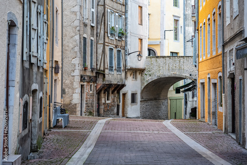 Picturesque alley with old stone houses and arched bridge in the medieval city of Pau  France.