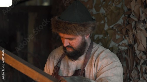 A working blacksmith on the street. Media. An adult man with a beard who forges iron on the street. photo