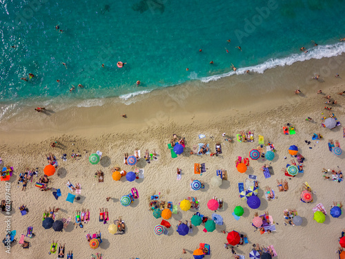 aerial view from the Caribbean sea drone of Tropea with its beach crowded with tourists with their colorful umbrellas. We are in Calabria Italy © cristian